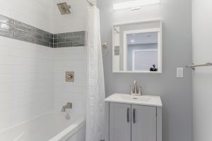 y baño blanco con lavabo y ducha. en Modern Downtown 3BR 2B Home, en Yellowknife