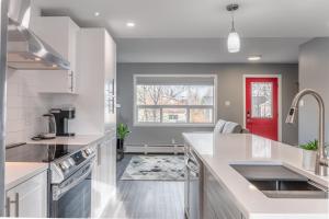 cocina con encimeras blancas y puerta roja en Modern Downtown 3BR 2B Home, en Yellowknife