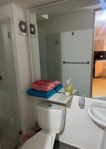 a bathroom with a toilet and a sink and a mirror at Apartaestudio central en Bogotá in Bogotá