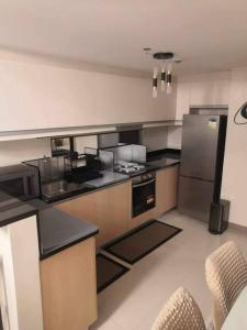 a kitchen with a stove and a refrigerator at Saint Honore Executive: 6 guests, 5 beds, 2 bedrooms, 2 bathrms in Iloilo City