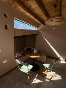 um quarto com uma mesa e duas cadeiras e uma cama em La Ventanita de Maima em Maimará