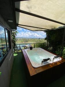 una bañera de hidromasaje en una terraza con vistas en Suite Gold Rocks Glamping en El Peñol