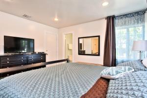 a bedroom with a large bed and a television at Walk To Disneyland, Watch Firework Front Yard, SPA in Anaheim
