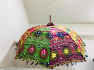 a colorful umbrella is hanging on a wall at Ali Baba Hostel in Jaipur