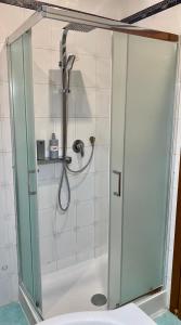 a shower with a glass door in a bathroom at Begonie House in Rome