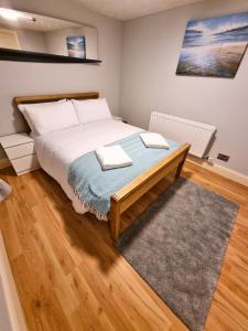 Schlafzimmer mit einem Bett und Holzboden in der Unterkunft Portrush by the Sea - 1 Golf Terrace in Portrush