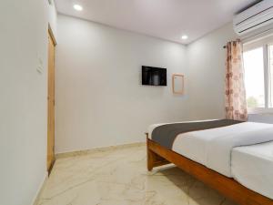 a bedroom with a bed and a tv on the wall at Collection O Hotel SR Grand in Bībīnagar