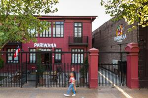 Uma menina a passar por um edifício vermelho em Pariwana Hostel Santiago em Santiago