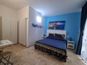1 dormitorio azul con 1 cama con pared azul en Agriturismo La Collina Verde, en Levanto