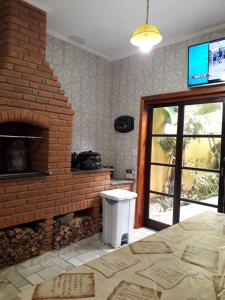 Cette chambre dispose d'une cheminée en briques et d'une télévision. dans l'établissement Kazapraia, à Mongaguá