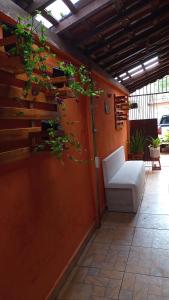 une terrasse avec un canapé blanc et une plante dans l'établissement Kazapraia, à Mongaguá