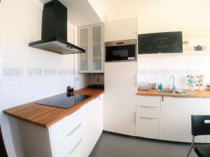 Be Local - Apartment with 3 bedroom near Oriente Station in Lisbon في لشبونة: مطبخ أبيض مع حوض وثلاجة