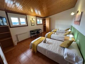 a bedroom with two beds and a table in it at Pensión Codesal in O Pedrouzo