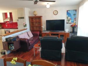 uma sala de estar com sofás e uma televisão de ecrã plano em Wallaroo Sea View home em Wallaroo