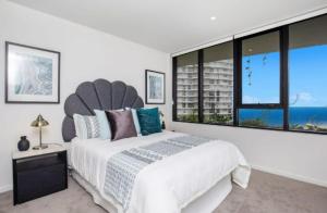 1 dormitorio blanco con 1 cama grande y ventanas grandes en Magnoli Apartments - Hosted by Burleigh Letting en Gold Coast