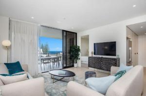 Sala de estar con 2 sofás, mesa y TV en Magnoli Apartments - Hosted by Burleigh Letting en Gold Coast