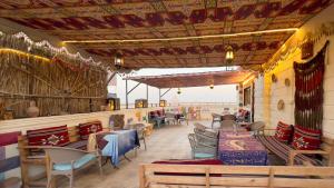 GizaにあるAtlantis Pyramids Inn Newのテーブルと椅子が備わるレストラン