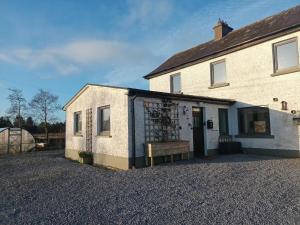 an old building with a bench outside of it at Connemara Lake View Apartment in Camus Eighter