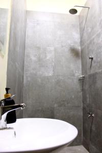 uma casa de banho com um lavatório branco e um chuveiro em Accra Luxury Apartments At The Sanga Estates em Accra