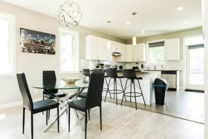 cocina con mesa de cristal y sillas negras en *Executive Home* Long Stays - Garage - WiFi & NFLX, en Edmonton