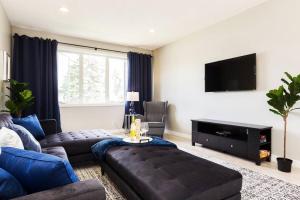 sala de estar con sofá y TV de pantalla plana en *Executive Home* Long Stays - Garage - WiFi & NFLX, en Edmonton