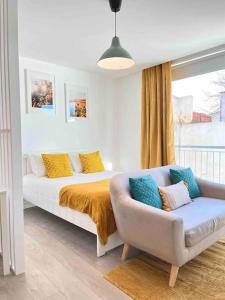 um quarto com uma cama, um sofá e uma janela em Domus da Ria em Aveiro