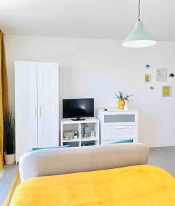 ein Wohnzimmer mit einem Sofa und einem TV in der Unterkunft Domus da Ria in Aveiro
