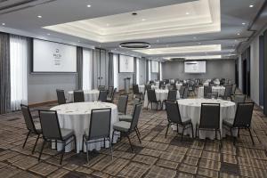 uma sala de conferências com mesas e cadeiras e um ecrã em Delta Hotels by Marriott Toronto Markham em Markham