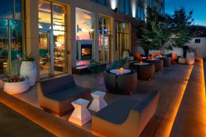 a patio with couches and tables on a building at Aloft Hotel Rogers Bentonville in Rogers