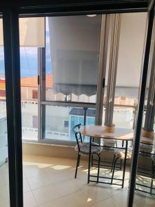 Una mesa y sillas en una habitación con ventana. en Lakeview Cozy Apartment, en Pogradec