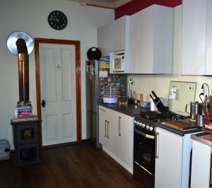 uma cozinha com armários brancos e um forno com placa de fogão em B&B La Nona em Valparaíso