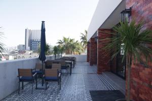 a row of tables and chairs on a rooftop patio at Hotel Wellintown in Tijuana