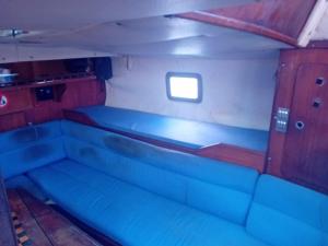 a room with blue seats in a boat with a window at Joli voilier de 13m in Les Trois-Îlets
