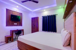a bedroom with a bed and a tv in it at OYO Blue Bell in Patna
