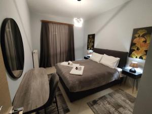 a bedroom with a bed and a table and a mirror at Sunset View in Ioannina