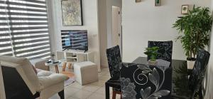 uma sala de estar com uma televisão e uma mesa e cadeiras em Departamento A 5 minutos del Centro de Rancagua I em Rancagua
