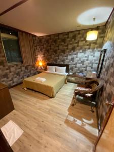 ein Schlafzimmer mit einem Bett und einem Schreibtisch in einem Zimmer in der Unterkunft Hotel Lee-Chan in Taipeh