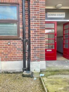 una puerta roja en un edificio de ladrillo con una puerta roja en Cozy One Bed Apartment Near Purley Station en Purley