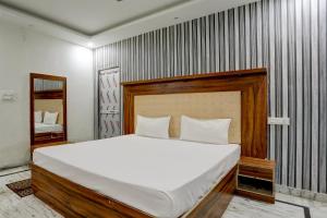 a bedroom with a large bed and a mirror at OYO Blue Bell in Patna