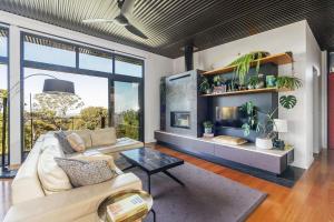 a living room with a couch and a fireplace at Sanctuaire, Southern Highlands in Mittagong