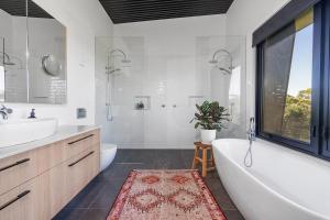 a white bathroom with a tub and a sink and a tubermott at Sanctuaire, Southern Highlands in Mittagong +16 photos