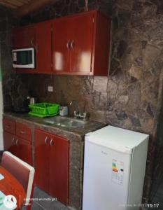 een keuken met rode kasten en een witte koelkast bij Flor de los andes in Fiambala