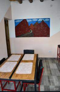een tafel en stoelen in een kamer met een schilderij aan de muur bij Flor de los andes in Fiambala