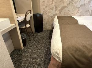 a bedroom with a bed and a desk and a chair at S.Training Center Hotel Osaka in Osaka