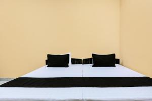 a bedroom with a large bed with black pillows at OYO Hotel H.R in Garhi Harsāru