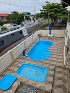 een zwembad op een patio met blauw water bij Casa de praia com piscina TOP in Paraty
