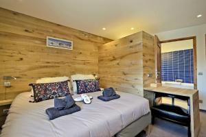 a bedroom with a large bed with a wooden wall at grand chalet LB-3-1 in Saint-Marcel