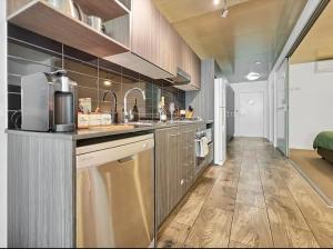 uma grande cozinha com electrodomésticos em aço inoxidável e pisos em madeira em Pavillion on Brookes em Brisbane