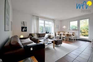a living room with a couch and a table at Ferienhaus Friesenblick Ferienwohnung 1 in Wangerooge