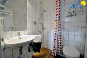 a bathroom with a sink and a toilet and a mirror at Ferienhaus Friesenblick Ferienwohnung 1 in Wangerooge +23 photos